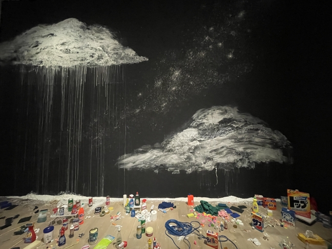 岩崎貴宏《アントロポセン》2023年　作家蔵洗剤の箱の中には20世紀の消費社会の象徴として、アンディ・ウォーホル作品で有名なブリロの箱も見える。壁に描かれたキノコ雲と銀河。２つの雲は広島と長崎を彷彿させる。筆者撮影