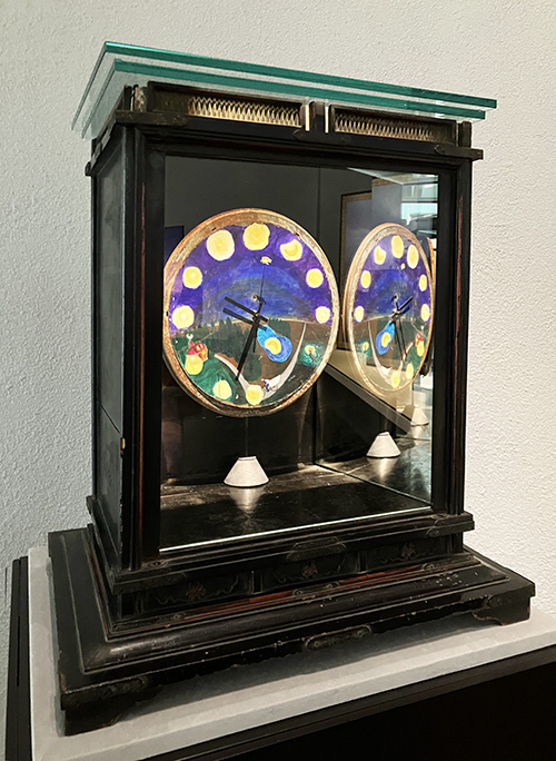 杉本博司《時間の間（はざま）》2023年、ミクストメディア：時計、厨子、鏡、ガラス、作家蔵杉本は1974年にニューヨークに渡った頃、パリのオペラ・ガルニエ宮の天井画と、ニューヨークのリンカーン・センターのオペラハウスの壁画がどちらもシャガールであったことに気づき、古い電気時計を分解し文字盤にシャガール風の絵を描いた。