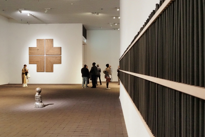 「神聖な空間」展示風景。常滑の香りをイメージして京都の香老舗、松栄堂との協働で制作したシアスター・ゲイツの彫刻作品《黒人仏教徒の香りの実践》（2024年／写真右）により展示室内には清々しい香りが漂う。本展では多くの職人や企業とコラボレーションした。奥の十字架は、シアスター・ゲイツの作品《アーモリークロス#2》（2022年）