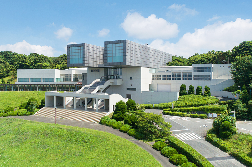 小倉、戸畑、八幡の三区にまたがる丘の上にある北九州市立美術館。臨海工業地帯と市街を見下ろす場所にある同館は、総面積10万平方メートルという緑豊かな広大な敷地内に建つ。