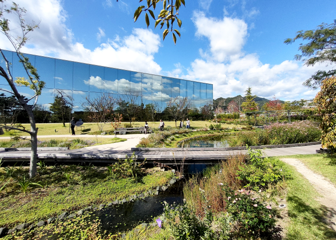 四季を通じて約250種の草花が目を楽しませてくれる「エミール・ガレの庭」。美術館のミラーガラスにも庭園の景色が映り込んで広がる