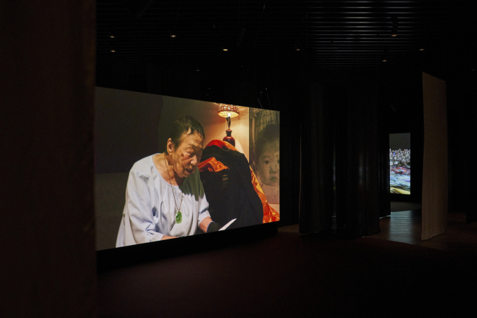 東京大空襲の記憶を語る亀谷敏子さん。山城知佳子《Recalling(s)》2025年、「山城知佳子×志賀理江子　漂着」展示風景、アーティゾン美術館　©Chikako Yamashiro. Photo: kugeyasuhide