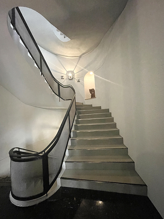 曲線の美しさにこだわった螺旋階段は、エントランスホールから地下1階、2階の展示室へと向かう動線。壁面の照明も白井晟一のデザインによるもの。
