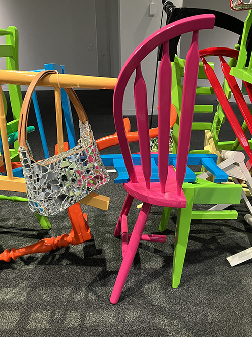 切断された椅子を複雑に組み合わせて作られた本作は、まるでアスレチックのようだ。「座る」という機能を失った椅子は、その特殊な造形が際立つ。随所にガラスの破片で作られたバッグがかかり、遊び心に溢れている。