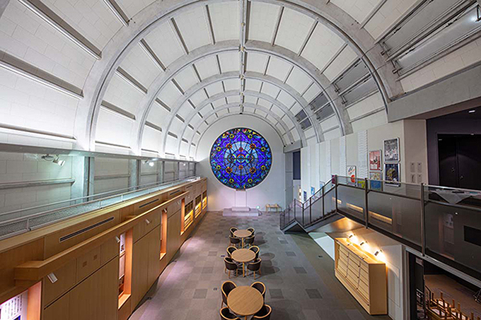 凝った幾何学文様の丸形のステンドグラスのある開放的なスペースは、交流ひろばとなっている。