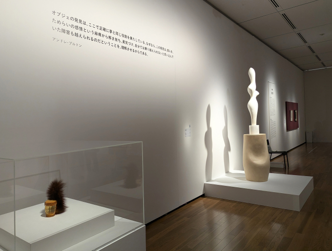 展示風景より、奥でライトが当たるのはジャン（ハンス）・アルプ《植物のトルソ》、本展では各所にあるテキストが展示を印象的に演出している