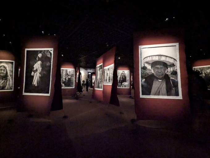 左側がコロンビアのスピリチュアルリーダー、右がメキシコのスピリチュアルリーダー。写真は大判の布に縫い合わされた状態でいくつも並んでいる。布は一部泥染めのコットンを用いた2種類のファブリックを使用。それらが石で床に固定されている様は、どこか遊牧民のテントを思わせる