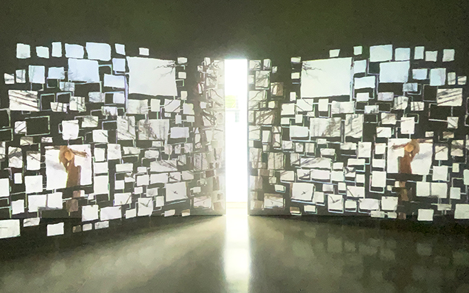 サラ・ジーの個展で展示された没入型ビデオ・インスタレーション『Pictures at an Exhibition』。空間全体に多数の紙のスクリーンが配置され、自然の風景、都市の喧騒、日常の断片的な画像などが映し出される。