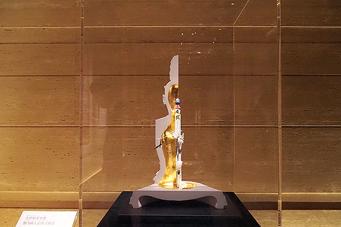 《大日如来坐像》の像内納入品原寸模型 協力：文化庁（ボアスコープ撮影）、東京国立博物館（X線断層撮影）上部に五輪塔形にかたどった木札が立ち、中ほどに水晶でできた珠、心月輪が留められている。