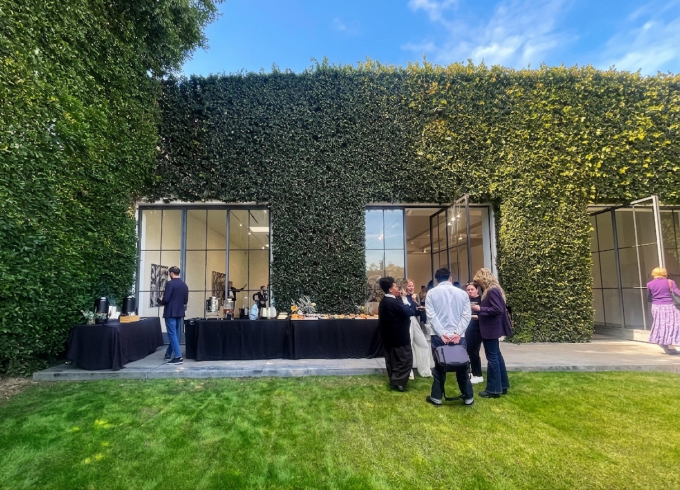 ペースギャラリーのレセプションの様子。緑に覆われた中庭に人々が集い語らう。 編集部撮影